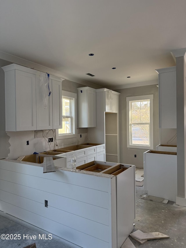 kitchen featuring ornamental molding and white cabinetry