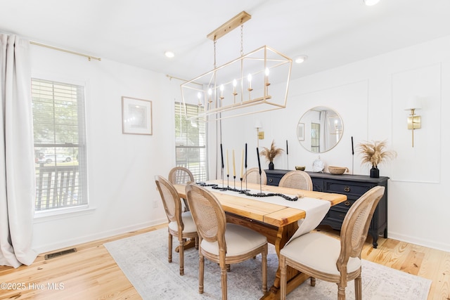 dining area with a chandelier and light hardwood / wood-style flooring