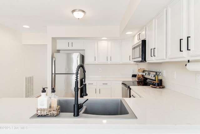 kitchen with white cabinets, appliances with stainless steel finishes, and sink