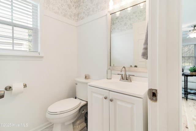 bathroom with toilet, ceiling fan, and vanity