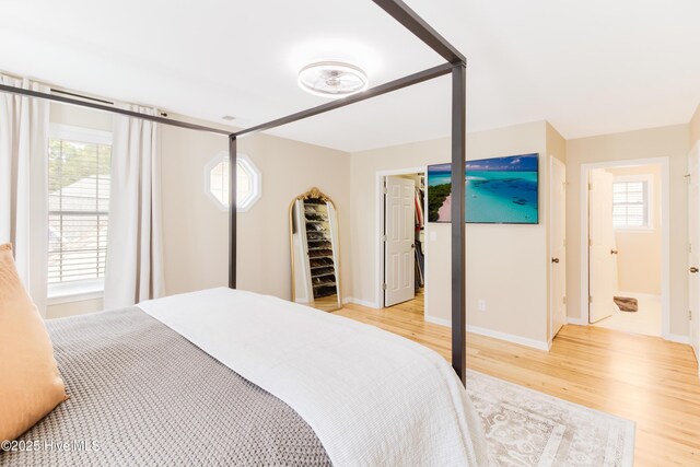 bedroom with ensuite bathroom and light hardwood / wood-style flooring