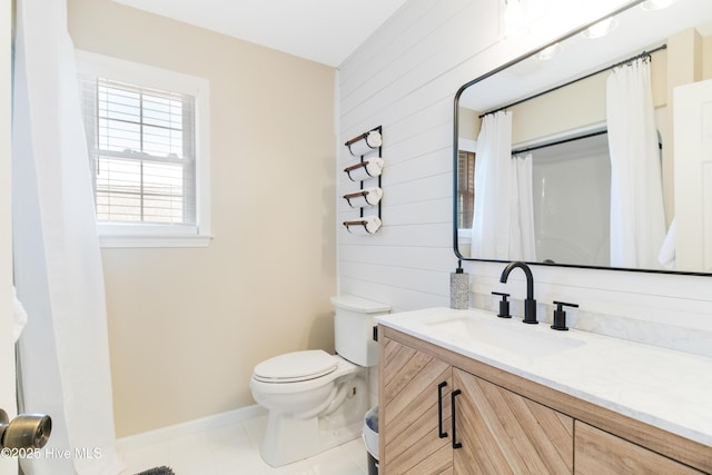 bathroom featuring toilet, vanity, wood walls, and tile patterned flooring