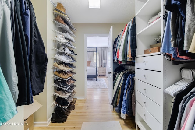 walk in closet with light wood-type flooring