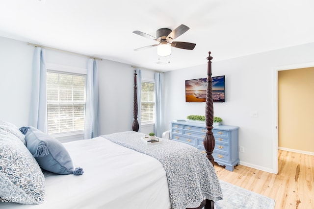 bedroom featuring ceiling fan, multiple windows, and light hardwood / wood-style flooring