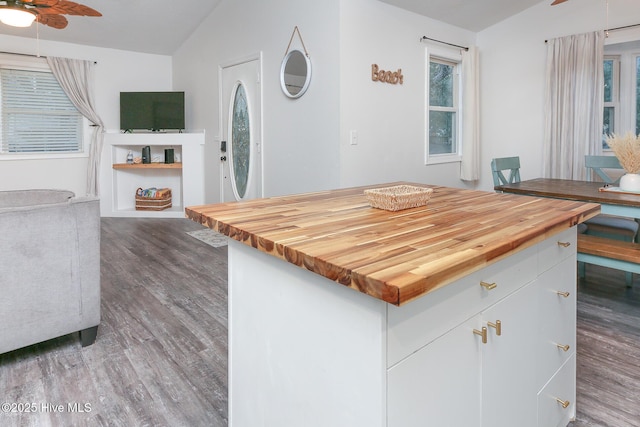 kitchen featuring wooden counters, ceiling fan, and vaulted ceiling