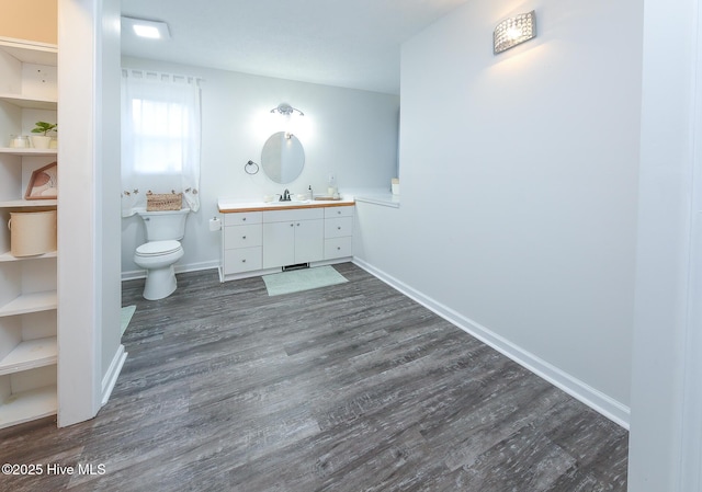 bathroom with toilet, vanity, and hardwood / wood-style flooring