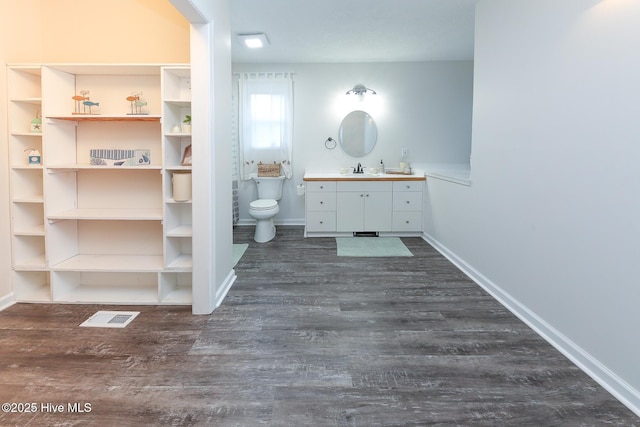 bathroom featuring toilet, vanity, and hardwood / wood-style flooring