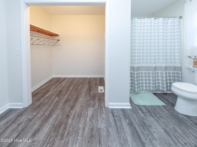 bathroom with toilet, hardwood / wood-style flooring, and a shower with shower curtain