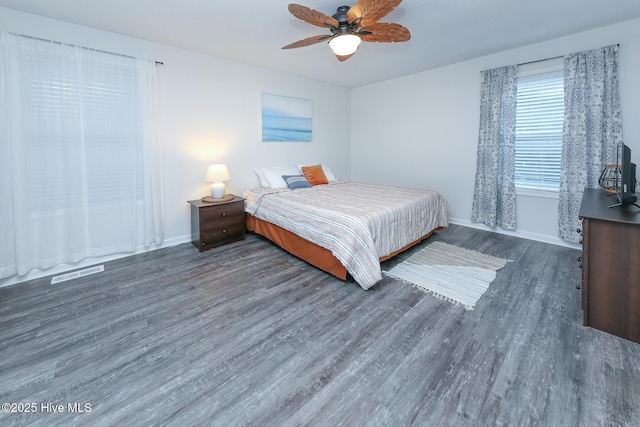 bedroom with dark hardwood / wood-style flooring and ceiling fan