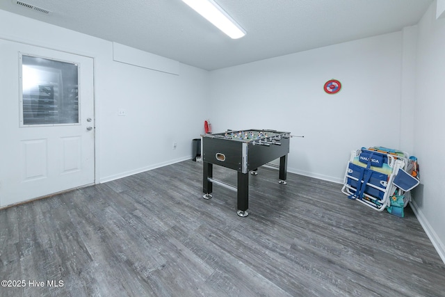 rec room with a textured ceiling and dark hardwood / wood-style flooring