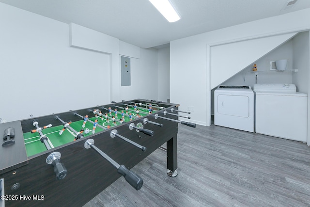 recreation room with hardwood / wood-style floors, electric panel, and independent washer and dryer