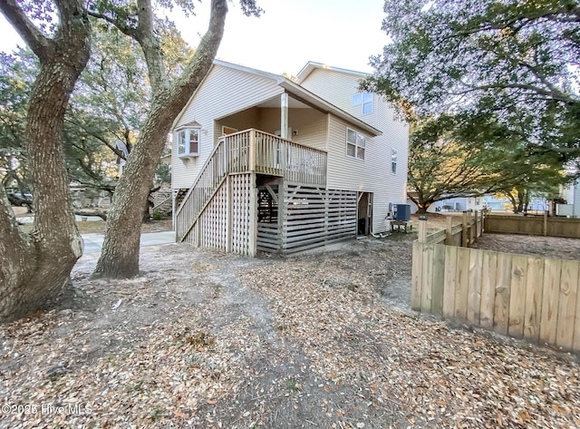 rear view of property featuring cooling unit and a wooden deck