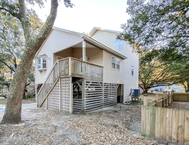 rear view of house with a wooden deck and central air condition unit