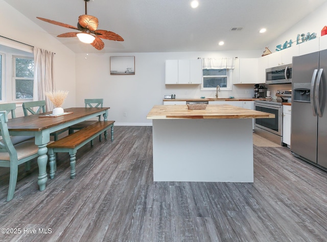 kitchen with dark hardwood / wood-style floors, stainless steel appliances, wood counters, white cabinetry, and sink