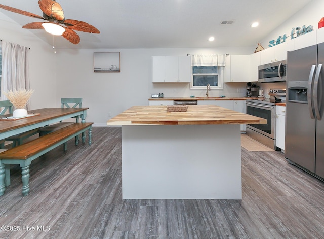 kitchen featuring stainless steel appliances, sink, white cabinets, a center island, and wood-type flooring