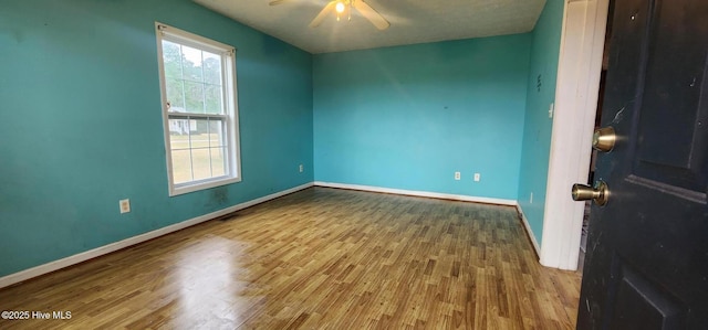 empty room with ceiling fan and hardwood / wood-style flooring