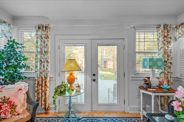 entryway with french doors, wood-type flooring, plenty of natural light, and crown molding