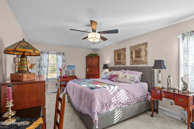 carpeted bedroom with ceiling fan and a baseboard heating unit