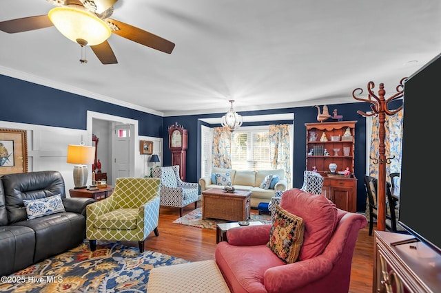 living room with ceiling fan with notable chandelier, ornamental molding, and hardwood / wood-style flooring