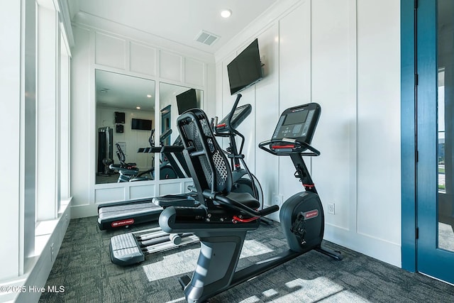 workout room featuring crown molding