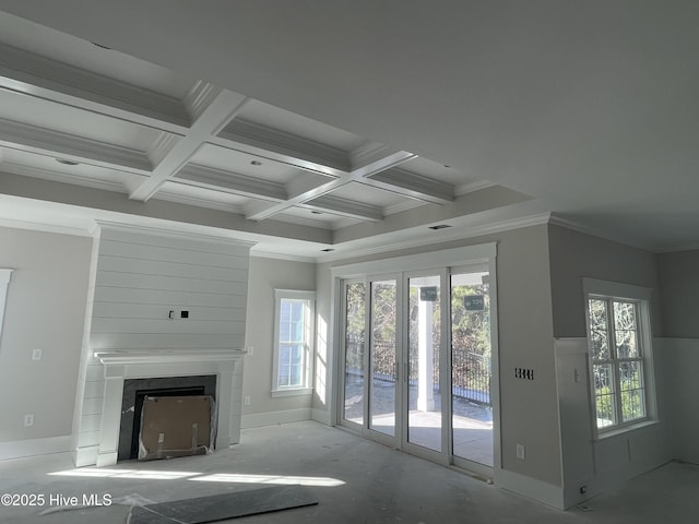 unfurnished living room featuring coffered ceiling, ornamental molding, plenty of natural light, and beam ceiling