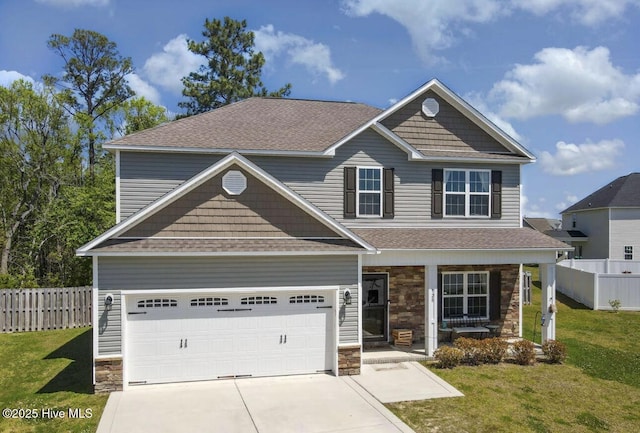 view of front of home with covered porch, a garage, and a front yard