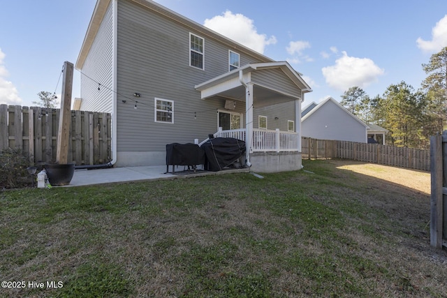 rear view of property with a patio and a lawn