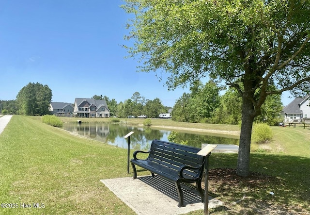 view of community with a yard and a water view