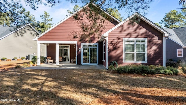 rear view of property featuring a patio area and a yard