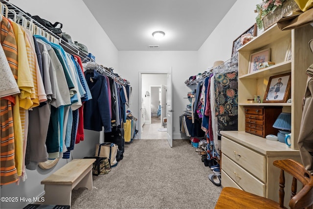 walk in closet featuring light colored carpet