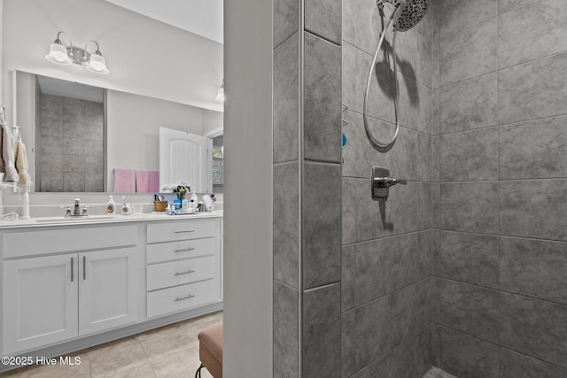 bathroom with tiled shower and vanity