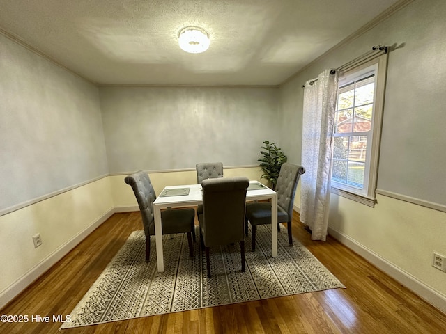 dining room with hardwood / wood-style floors and a textured ceiling