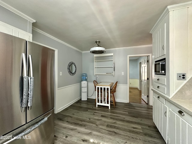 kitchen featuring white cabinetry, ornamental molding, appliances with stainless steel finishes, and dark hardwood / wood-style flooring