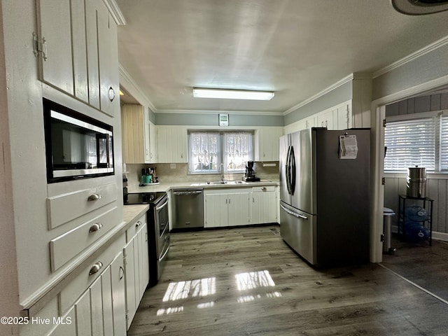 kitchen featuring sink, appliances with stainless steel finishes, tasteful backsplash, light hardwood / wood-style floors, and white cabinets