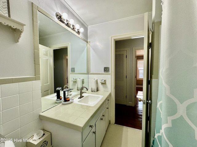 bathroom featuring vanity, crown molding, and tile walls