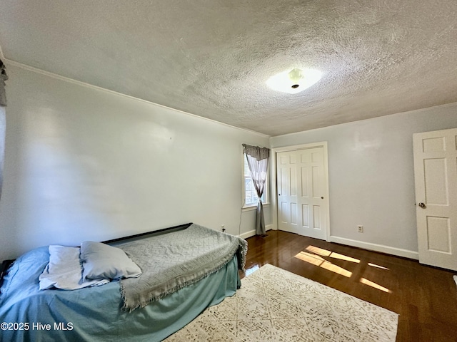 bedroom with dark hardwood / wood-style flooring, a closet, and a textured ceiling