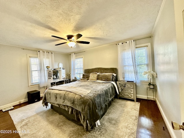 bedroom featuring ceiling fan, ornamental molding, dark hardwood / wood-style floors, and a textured ceiling