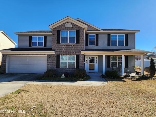 view of front facade with a porch, a front yard, and a garage