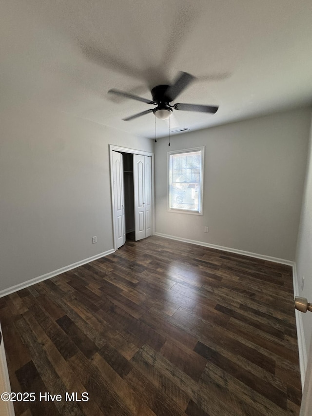 unfurnished bedroom with dark wood-type flooring, ceiling fan, a closet, and a textured ceiling