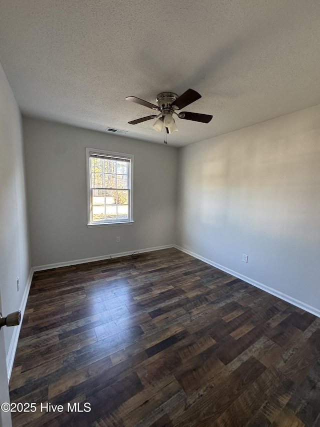 unfurnished room featuring ceiling fan, dark wood-type flooring, and a textured ceiling