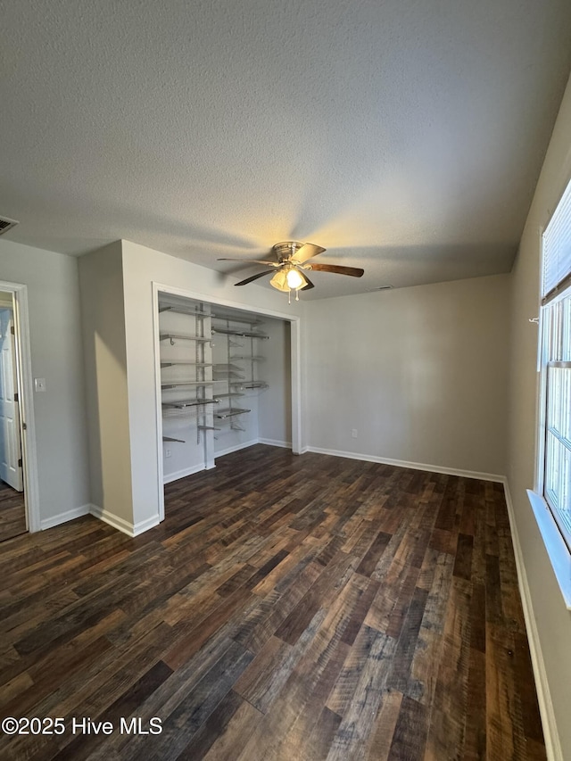 interior space featuring dark wood-type flooring, ceiling fan, a closet, and a textured ceiling