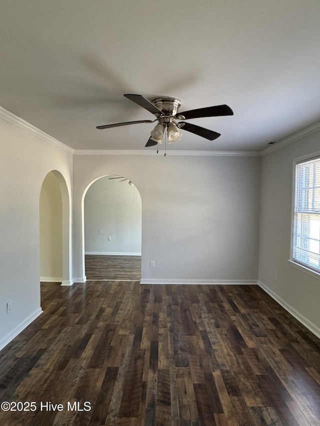 empty room with ornamental molding, ceiling fan, and dark hardwood / wood-style flooring