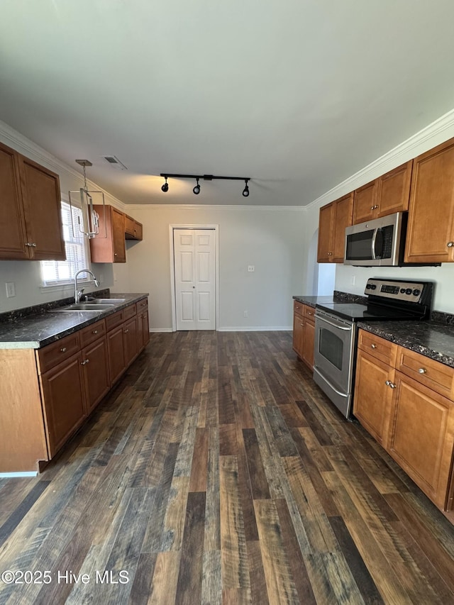 kitchen featuring sink, crown molding, appliances with stainless steel finishes, hanging light fixtures, and dark hardwood / wood-style floors