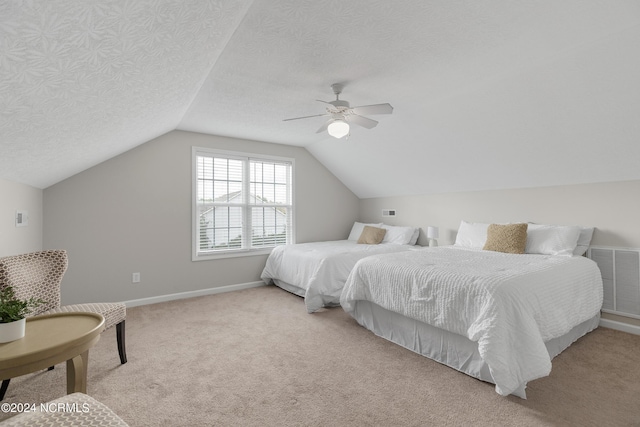 carpeted bedroom featuring vaulted ceiling, a textured ceiling, and ceiling fan