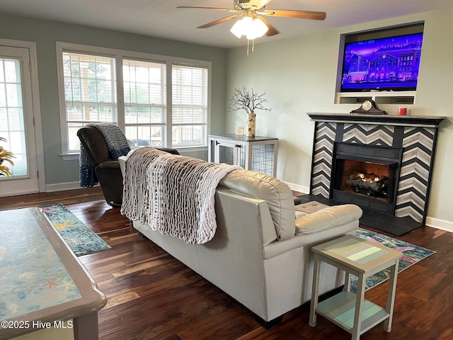 living room with ceiling fan, dark hardwood / wood-style flooring, and a tile fireplace