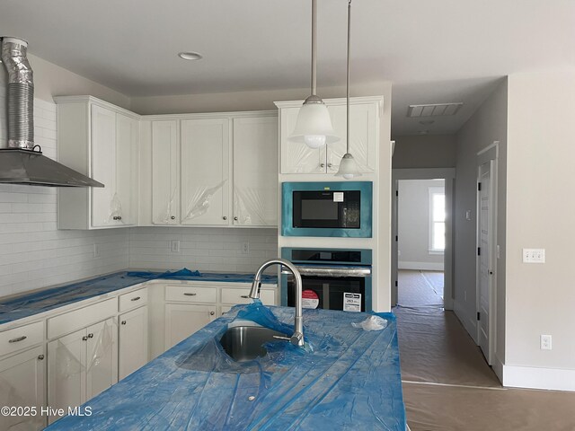 kitchen featuring oven, decorative light fixtures, built in fridge, lofted ceiling, and a kitchen bar