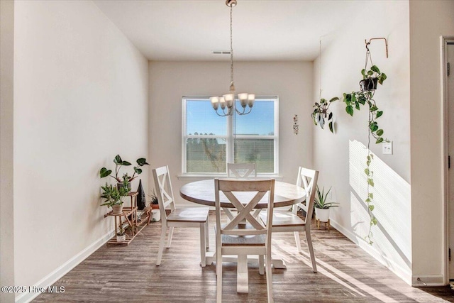 dining space with an inviting chandelier and dark hardwood / wood-style floors