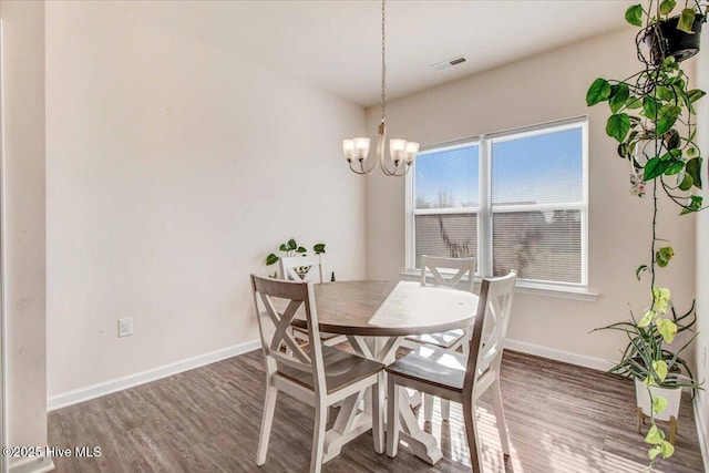 dining room featuring an inviting chandelier and dark hardwood / wood-style flooring