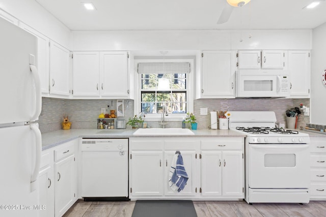 kitchen with sink, ceiling fan, white cabinets, white appliances, and backsplash