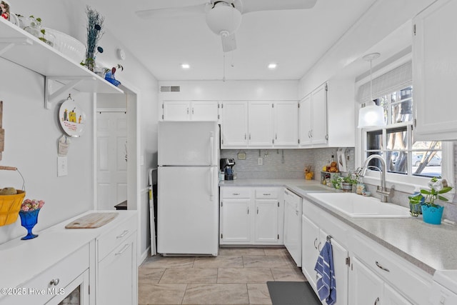 kitchen featuring sink, backsplash, white cabinets, light tile patterned floors, and white appliances